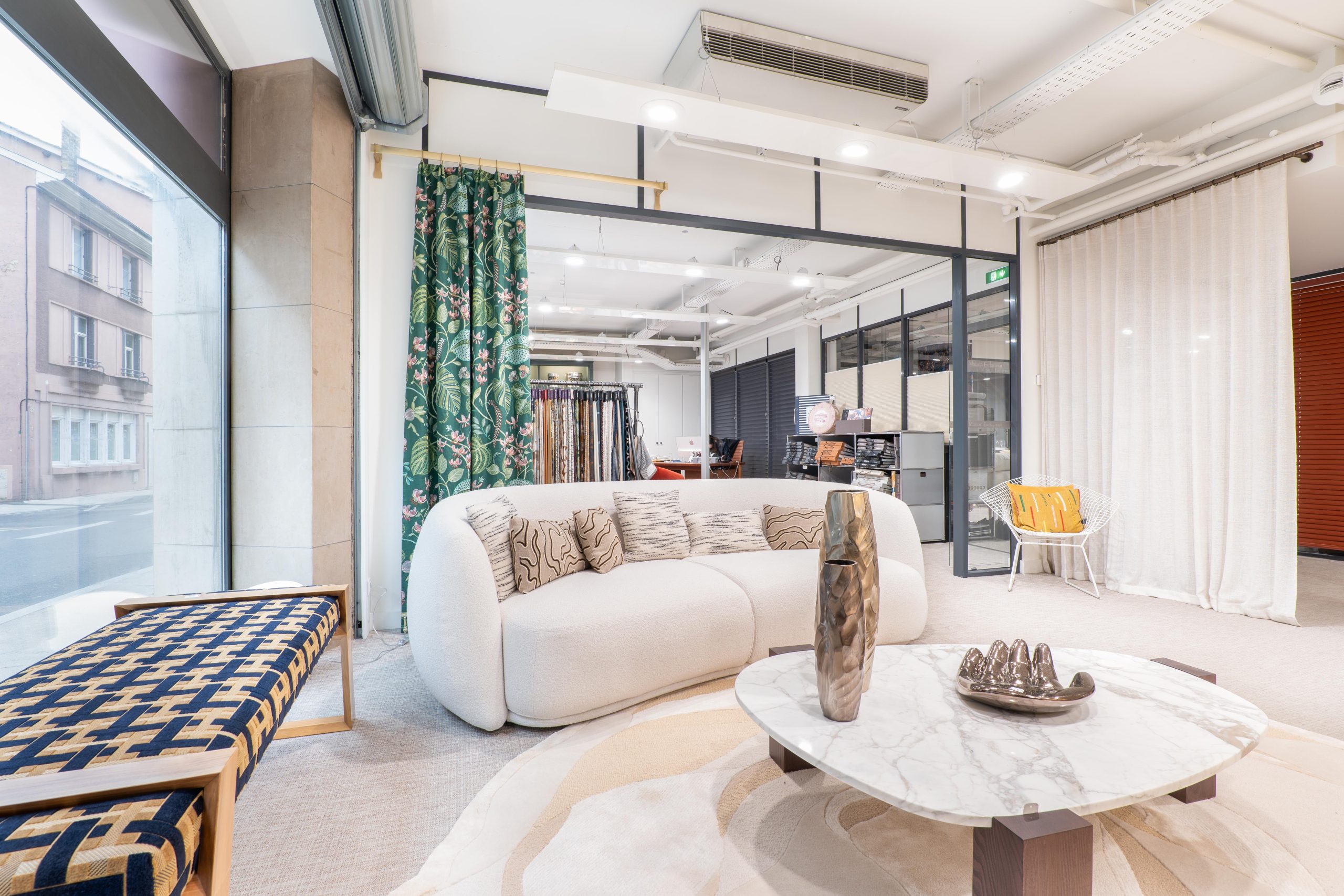 Espace showroom de la Maison Esclavissat à Mâcon : canapé, rideaux et banquette tapissée