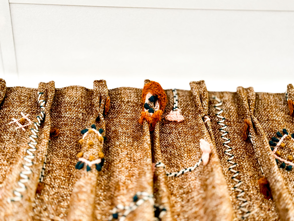 Détail de plis pincés sur tissu brodé main — atelier Maison Esclavissat