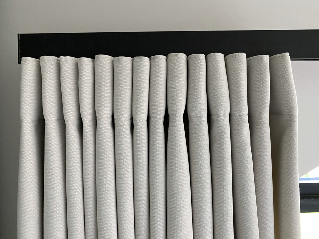 Détail de plis sur rail noir, tissu écru — atelier Maison Esclavissat