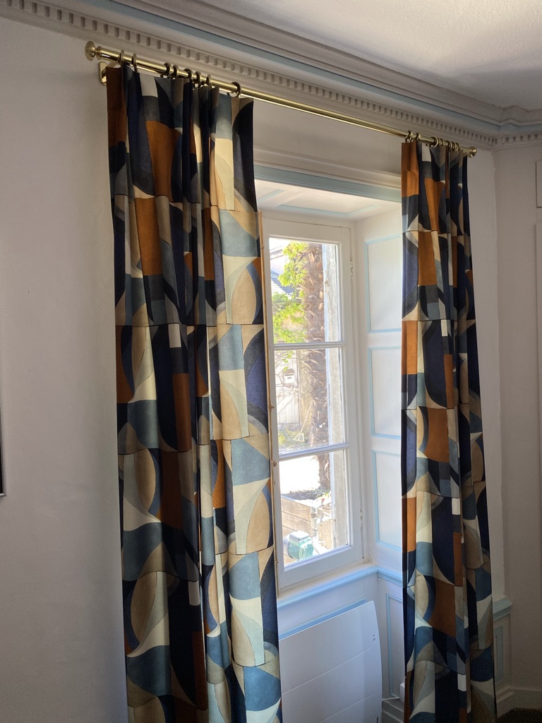 Rideaux imprimé géométrique bleu et orange sur tringle laiton — Maison Esclavissat