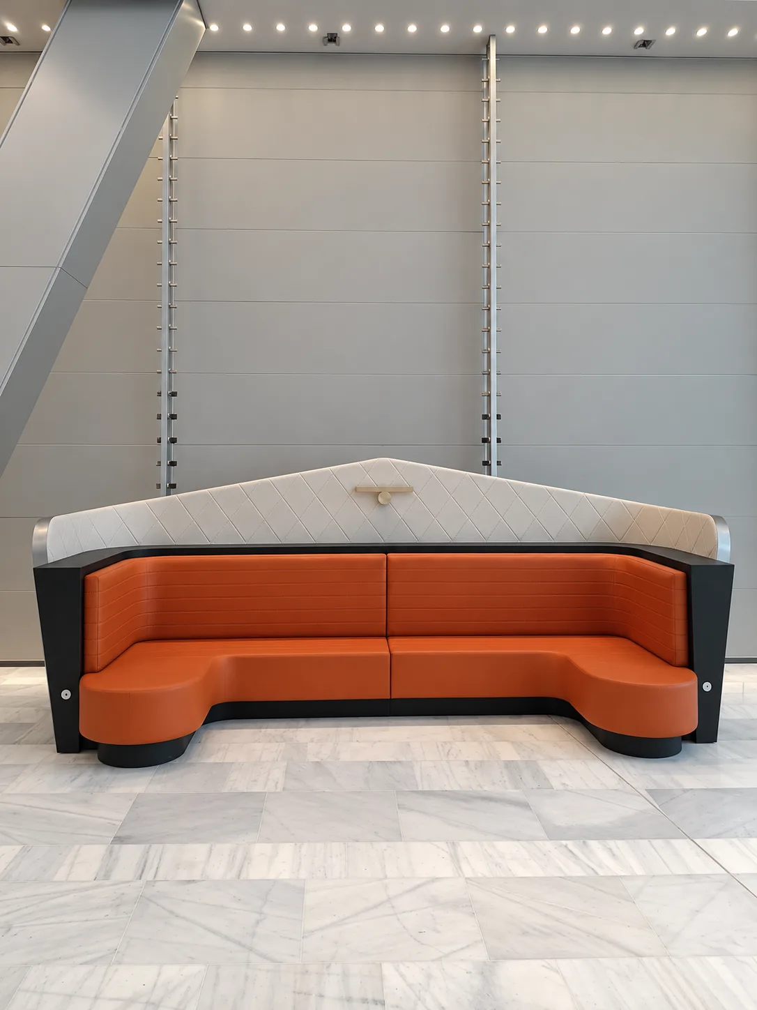 Banquette sur mesure en cuir orange et dossier capitonné en losanges, réalisée par Maison Esclavissat