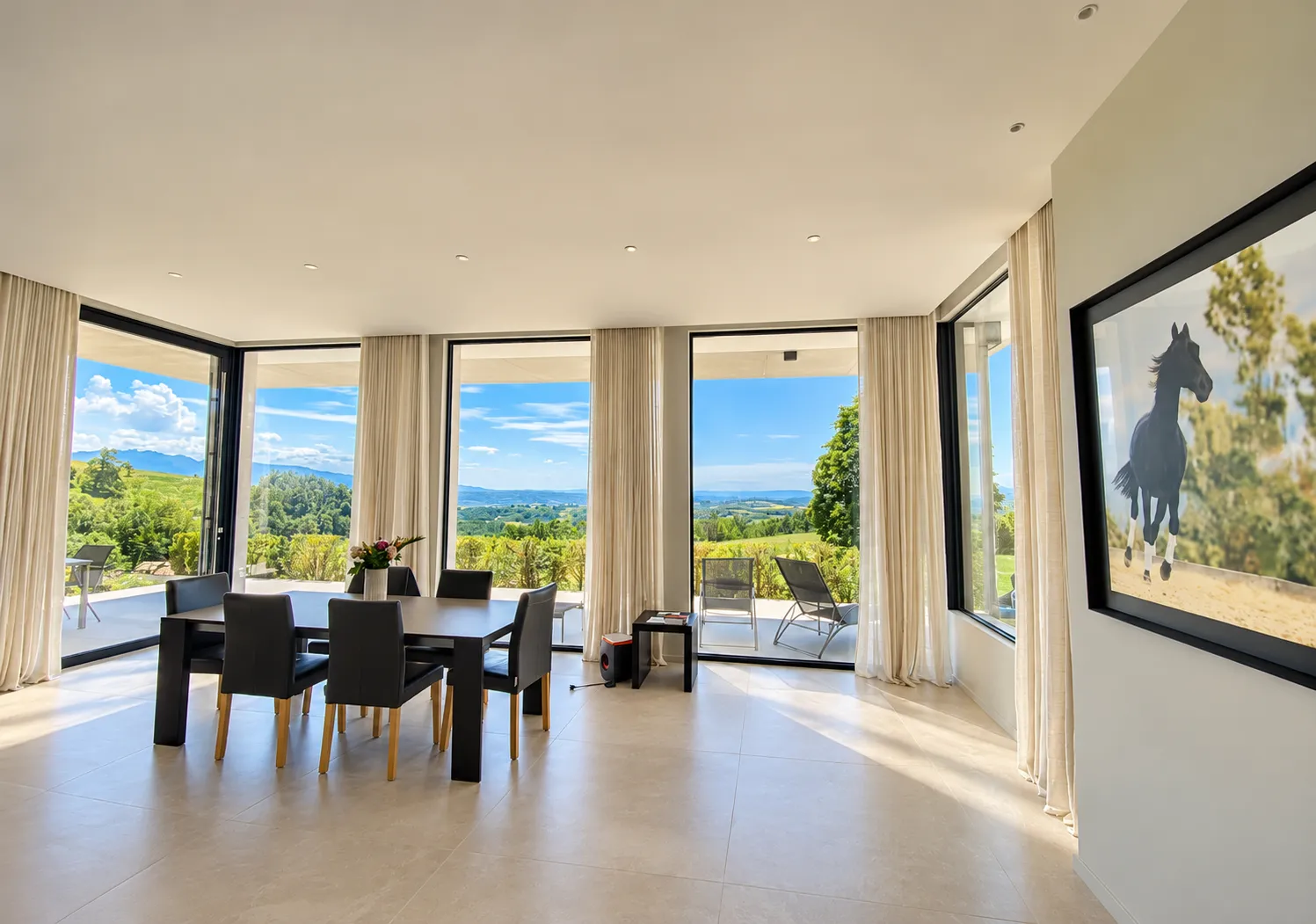 Voilages en lin confectionnés et posés par Maison Esclavissat sur les baies panoramiques d'une villa